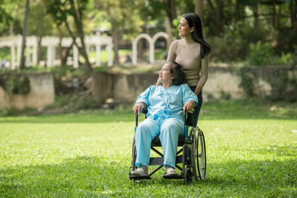 Cuidadora com idosa em cadeira de rodas